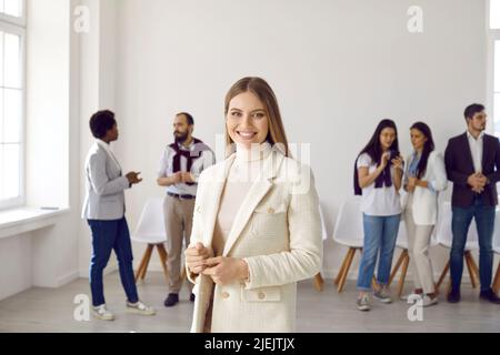 Lächelnde Angestellte, die im Büro posiert Stockfoto