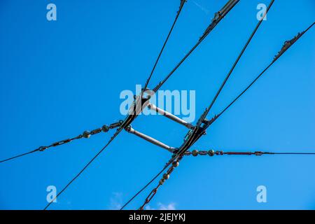 Oberleitung und Kontaktleitungen für ein elektrisches Trolley-Bus-System mit einem schlichten blauen Himmel Hintergrund. Stockfoto