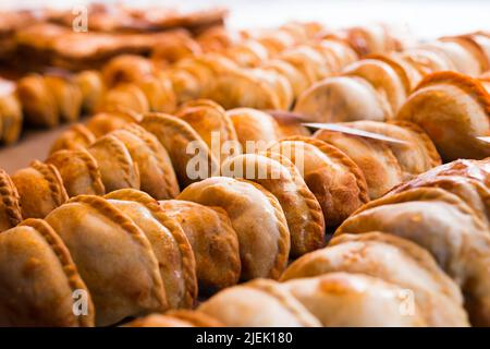Frisch gebackene Empanadas mit verschiedenen Füllungen zum Verkauf Stockfoto