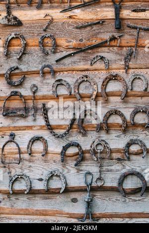 Set aus alten rostigen Hufeisen auf einem hölzernen Hintergrund Stockfoto