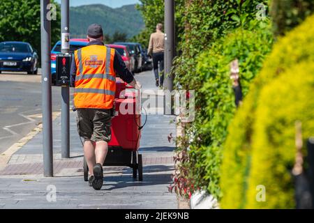 Royal Mail Postbote bei seiner Lieferrunde in Warrenpoint, County Down, Nordirland, Großbritannien. Stockfoto