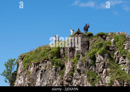 Touristen im Fairy Glen auf der Halbinsel Trotternish. Abwechslungsreiche Landschaft mit Hügeln, Tälern und Basaltklippen im Norden von Skye. Gebiet leidet unter Übertourismus. Stockfoto