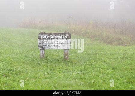 Big Spy Mountain überblicken den Eingang des Wegzeichens mit berühmter Aussicht bei Nebel auf dem Blue Ridge Parkway, Virginia National Park in der Herbstsaison und gr Stockfoto