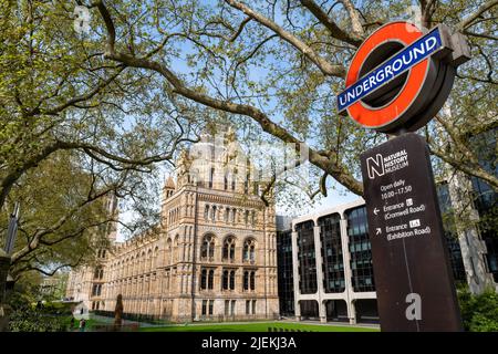 London, Großbritannien - 17.. April 2022: Außenansicht des Natural History Museum mit Schild und Informationschild der Londoner U-Bahn. Stockfoto