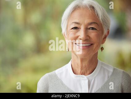 Copyspace mit lächelnder älterer Frau. Porträt einer glücklichen Dame mit grauem Haar, die einen sorglosen Ruhestand genießt. Das Gesicht von fröhlichem, entspanntem und weisen Alten Stockfoto