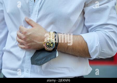 MAILAND, ITALIEN - 18. JUNI 2022: Mann mit goldenen und bunten Edelsteinen Uhr vor Marcelo Burlon County of Milan Fashion Show, Milan Fashion Week Street st Stockfoto