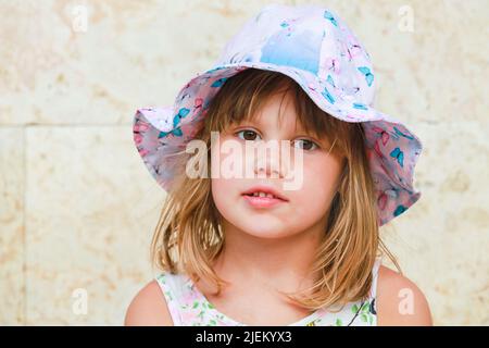 Niedliche europäische Baby-Mädchen in bunten Panama-Hut, Nahaufnahme Gesicht Porträt Stockfoto
