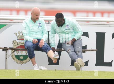 Schalke, Deutschland. 27.. Juni 2022. firo: 06/27/2022, Fußball, Fußball: 1.Bundesliga: Schalke 04 Trainingsmanager Rouven Schroder zeigt Gerald Asamoah seinen Fuß, Witz, Humor Credit: dpa/Alamy Live News Stockfoto