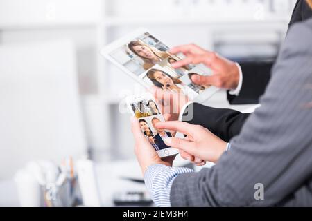Hände von Geschäftspartnern, die Geräte verwenden Stockfoto