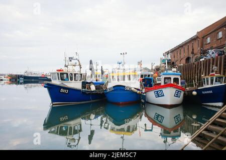 Kleine Fischerboote an der Küste vor dem Kai im Hafen von Scarborough Stockfoto