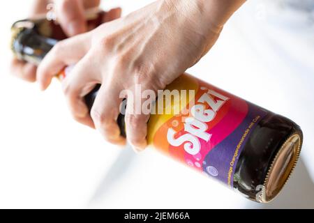 München, Deutschland. 27.. Juni 2022. Eine junge Frau öffnet eine Flasche Spezi für eine Illustration. Kredit: Lennart Preiss/dpa/Alamy Live Nachrichten Stockfoto