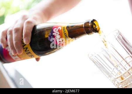 München, Deutschland. 27.. Juni 2022. Eine junge Frau gießt Spezi zur Illustration in ein Glas. Kredit: Lennart Preiss/dpa/Alamy Live Nachrichten Stockfoto