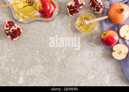 Festliche Komposition des jüdischen Neujahrs Rosh Hashanah mit traditionellen Symbolen des Feiertages. Grauer Hintergrund. Ein Kopierraum Stockfoto