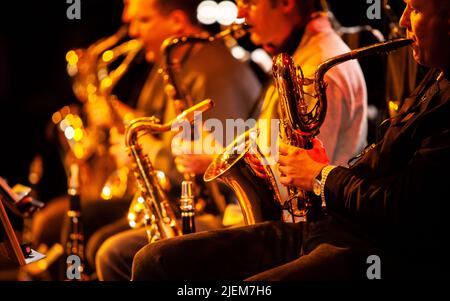 Big Band: Die Sax-Sektion. Konzentrieren Sie sich auf das Bariton-Saxophon im Vordergrund. Aus einer Reihe von Bildern von Musikern in einer Swing Jazz Band. Stockfoto