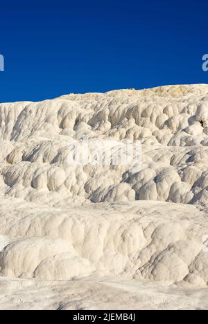 Die Travertinbecken und Terrassen in Pamukkale, Türkei. Wüstensand mit kurviger Musterstruktur vor blauem Himmel. Tourismus Urlaubsziel in Rock Stockfoto