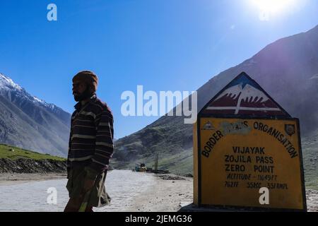 27. Juni 2022, Ladakh, Jammu und Kashmir, Indien: Ein Arbeiter geht an einem Meilenstein entlang der Autobahn am Zojila Pass vorbei, 108 Kilometer östlich von Srinagar in Zojila, Indien. Zojila einer der gefährlichen Bergpässe in der Kaschmir-Region, die die einzige Straßenverbindung zwischen Kaschmir und Ladakh, die strategische Bedeutung hat, wie Zojila Pass liegt in einer Höhe von 11.578 Fuß auf dem Srinagar-Kargil-Leh National Highway und bleibt während der Winter wegen schwerer geschlossen Schneefall und in diesem Jahr ist der Pass am 19. März geöffnet, nachdem er für 73 Tage geschlossen bleibt. (Bild: © Adil Abbas/Z Stockfoto