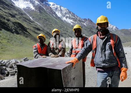 27. Juni 2022, Ladakh, Jammu und Kaschmir, Indien: Nicht-lokale Arbeiter sehen sich an, wie die Posen für ein Bild am Zojila Pass, 108 Kilometer östlich von Srinagar in Zojila, Indien, entstehen. Zojila einer der gefährlichen Bergpässe in der Kaschmir-Region, die die einzige Straßenverbindung zwischen Kaschmir und Ladakh, die strategische Bedeutung hat, wie Zojila Pass liegt in einer Höhe von 11.578 Fuß auf dem Srinagar-Kargil-Leh National Highway und bleibt während der Winter wegen schwerer geschlossen Schneefall und in diesem Jahr ist der Pass am 19. März geöffnet, nachdem er für 73 Tage geschlossen bleibt. (Bild: © Adil Abbas/ Stockfoto