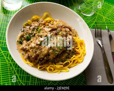 Schweineribs mit Pilzsauce und Linguinnudeln. Stockfoto