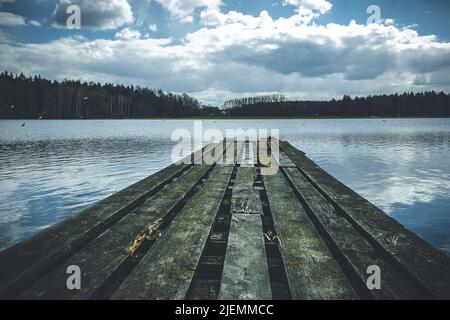 Ein alter, hölzerner Steg an einem herbstlichen See Stockfoto
