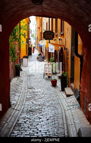 Stockholm, Schweden - 25. Juli 2017: Tor und gemütliche alte Straße mit Cafés in der Altstadt von Stockholm Stockfoto