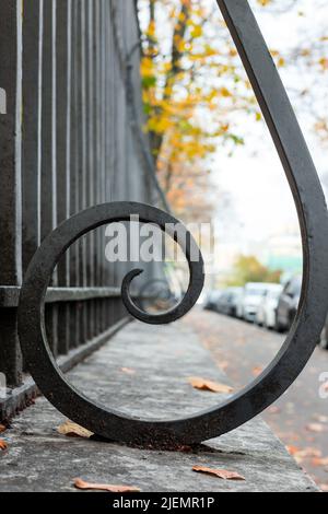 Schwarz geschmiedete Spirale, Metallzaun Details, Nahaufnahme mit selektivem Fokus. Klassische Architektur der Sankt-Petersburger Altstadt, Russland Stockfoto