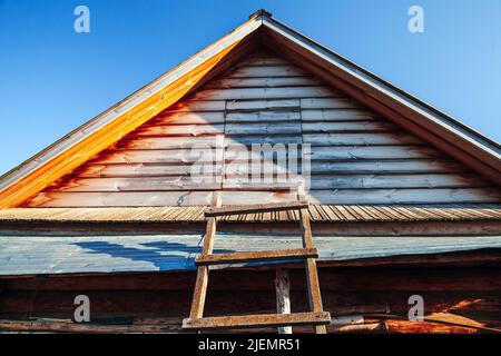 Altes Holzhaus außen Fragment, Dach und Leiter Stockfoto