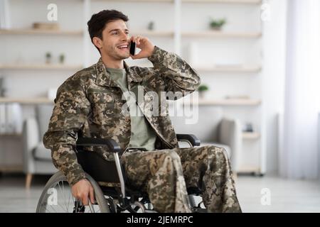 Glücklicher Veteran, der mit seinem Freund Combat telefoniert Stockfoto