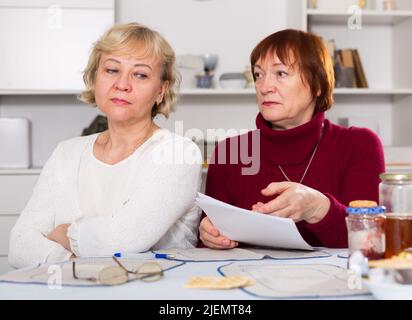 Ältere Frau erklärt beleidigtes Weibchen das Dokument Stockfoto