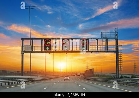 Highway Road zu Sonnenuntergang Wolken. 130 km/h Geschwindigkeitsbegrenzungszeichen Stockfoto