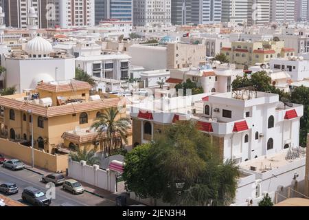 Villen Wohngebiet von Abu Dhabi mit modernen Hochhäusern im Hintergrund. Moderne Stadtarchitektur im Nahen Osten. Stockfoto