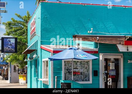 Tarpon Springs, USA - 4. Oktober 2021: Farbenfrohe blau-türkise Architektur in der griechisch-europäischen Kleinstadtstraße in Florida Schild für Dock's Waterfront Stockfoto