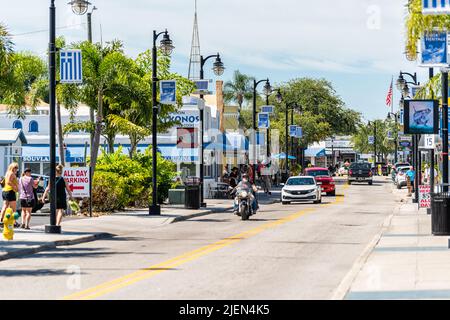 Tarpon Springs, USA - 4. Oktober 2021: Florida Griechische Stadt Fischerdorf Dodecanese Boulevard Straße Bunte Gebäude mit blauen Fahnen und Menschen Stockfoto