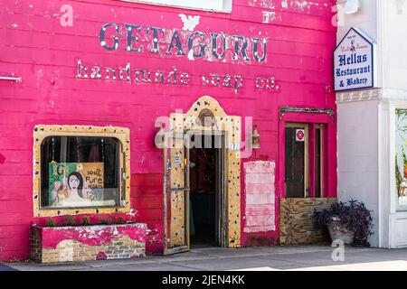 Tarpon Springs, USA - 4. Oktober 2021: Florida Griechenland Stadt Dodecanese Boulevard Straße rosa Gebäude Architektur mit Zeichen für handgemachte Seife und Hölle Stockfoto