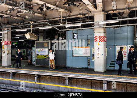 Shinagawa, Japan - 17. April 2019: Bahnsteig des Hauptbahnhofs mit ehrlicher Geschäftsleuten, die auf Schienen auf den JR shinkansen nach arri warten Stockfoto