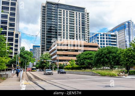 Dallas, USA - 7. Juni 2019: Downtown Street Road by Park im Sommer mit Menschen Fußgänger und Skyline Blick auf moderne Gebäude in Dallas, T Stockfoto