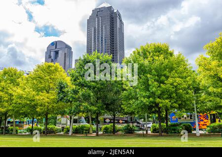 Dallas, USA - 7. Juni 2019: Downtown Klyde Warren Park im Sommer mit Rasen Gras, Bäumen, Food Trucks und Gebäuden Türme Stadtbild an bewölktem Tag in D Stockfoto