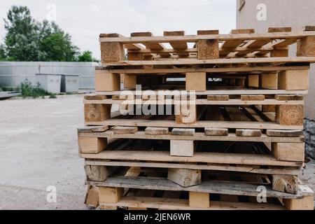 Auf der Straße liegen Holzpaletten übereinander Stockfoto