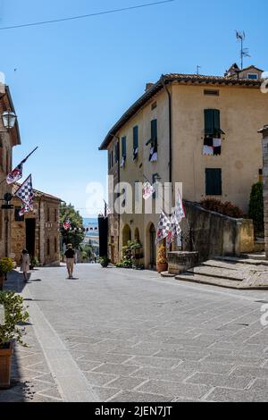 Via Dante Alighieri in der Sommersonne, San Quirico d'Orcia, Toskana, Italien Stockfoto