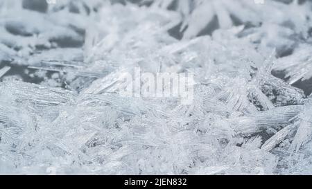 Eis- und Schneekristalle bilden Spitzenformen auf gefrorenem Fluss, Nahaufnahme Makrodetails, abstrakter Winterhintergrund Stockfoto