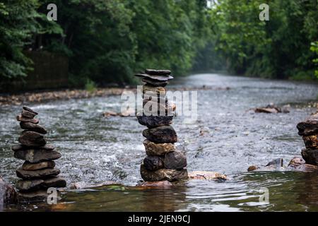 Steine sorgfältig auf sanft fließenden Fluss gestapelt Stockfoto