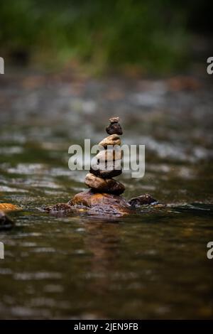 Steine sorgfältig auf sanft fließenden Fluss gestapelt Stockfoto