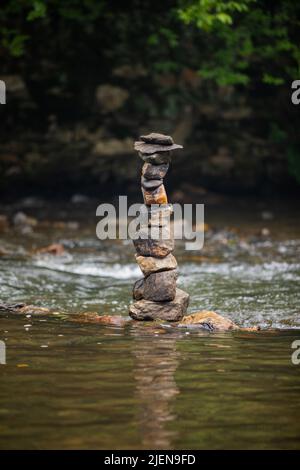 Steine sorgfältig auf sanft fließenden Fluss gestapelt Stockfoto