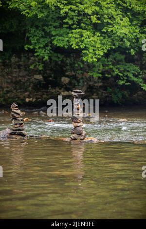 Steine sorgfältig auf sanft fließenden Fluss gestapelt Stockfoto