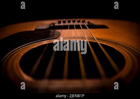 Gitarre.Gitarrenakkorde.Akustische Gitarre.Musik.Musikhintergrund.Bild einer Akustikgitarre im Dunkeln.Gitarrenmusik spielen. Akustik-Gitarrenakkorde. Stockfoto