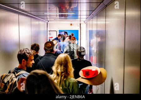 Schiphol, Niederlande. 26.. Juni 2022. Eine lange Schlange von Reisenden wird gesehen, wie sie auf dem Weg zum Flughafen Schiphol durch eine Jetbrücke gehen. Der Flughafen warnt nun unmissverständlich davor, dass es in den kommenden Wochen stundenlange Warteschlangen geben könnte. In der kommenden Zeit wird es ungefähr so voll sein wie während der Maifeiertage. KLM bremst den Verkauf von Tickets für Flüge ab Schiphol in den kommenden Tagen. Kredit: SOPA Images Limited/Alamy Live Nachrichten Stockfoto