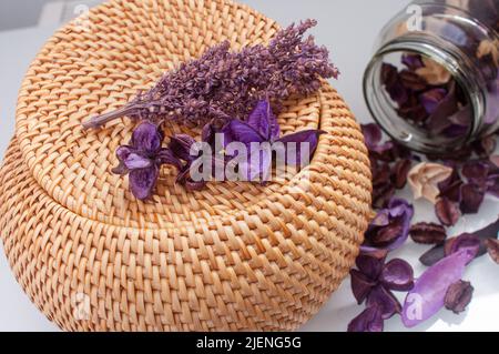 Korbstrohbox Handwerk rund auf der Oberseite mit getrockneten Blumen und Lavendel auf weißem Hintergrund Stockfoto