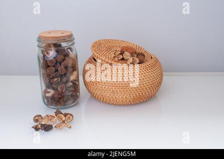 Korbstrohbox Handwerk rund auf der Oberseite mit getrockneten Blumen und Lavendel auf weißem Hintergrund Stockfoto