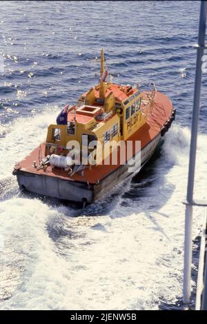 Ein Bild aus dem Jahr 1984 (Kodachrome) eines Hafenlotsenschiffes, möglicherweise des Gouverneurs Bligh oder Governor King, neben dem TSS Fairstar im Hafen von Sydney Stockfoto