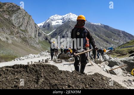 Zojila, Indien. 27/06/2022, Arbeiter arbeiten auf einer Autobahn, die zum Zojila Pass führen, 108 Kilometer östlich von Srinagar in Zojila, Indien. Zojila einer der gefährlichen Bergpässe in der Kaschmir-Region, die die einzige Straßenverbindung zwischen Kaschmir und Ladakh, die strategische Bedeutung hat, wie Zojila Pass liegt in einer Höhe von 11.578 Fuß auf dem Srinagar-Kargil-Leh National Highway und bleibt während der Winter wegen schwerer geschlossen Schneefall und in diesem Jahr ist der Pass am 19. März geöffnet, nachdem er für 73 Tage geschlossen bleibt. (Foto von Adil Abass/Pacific Press) Stockfoto