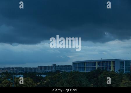 Der Himmel war mit dicken Wolken am Himmel geschichtet. Die Gebäude und Bäume unter den Wolken sahen kurz aus Stockfoto